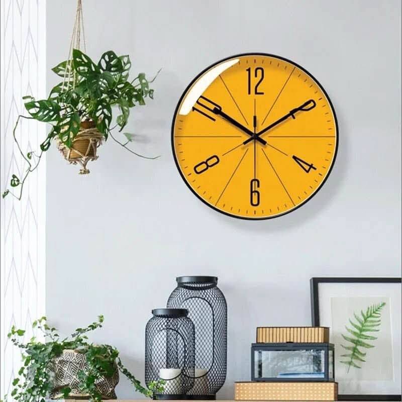Kelvar wandklok in goud frame with orange-coloured dial van duurzaam kunststof with glas crystal front – in een woonkamer
